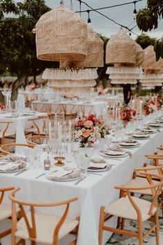 an outdoor dining area with tables, chairs and umbrellas hanging from the rafters