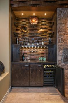 a wine cellar in the corner of a room with stone walls and wooden shelves filled with bottles