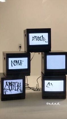 four televisions with different types of writing on them sitting in front of each other