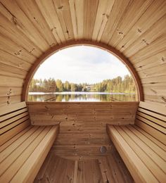 the inside of a wooden sauna with two benches and a lake in the background