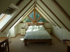 an attic bedroom with a bed and dressers