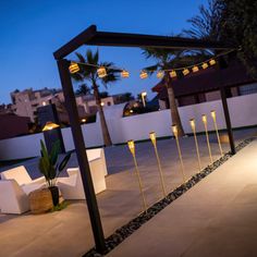 an outdoor area with white chairs and lights