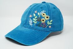 Flower is 100% hand embroidered on a 100% cotton wash black baseball cap. Hat is one size fits all with adjustable back strap. Unique cap, one of a kind! I am also open for customization. If you want the item in different colors, please message me, it will take additional 2-3 days of handling time. Free first class shipping, upgradable priority mail service. 30 days return policy, feel confident at your purchase! Blue Embroidered Curved Brim Hats, Spring Blue Baseball Cap With Embroidered Logo, Blue Visor Baseball Cap For Spring, Blue Embroidered Baseball Cap For Summer, Adjustable Embroidered Blue Hat, Embroidered Blue Spring Hats, Spring Embroidered Blue Hats, Blue Embroidered Spring Hats, Blue Embroidered Visor Baseball Cap