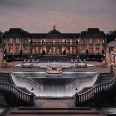 a large mansion with a fountain in front of it