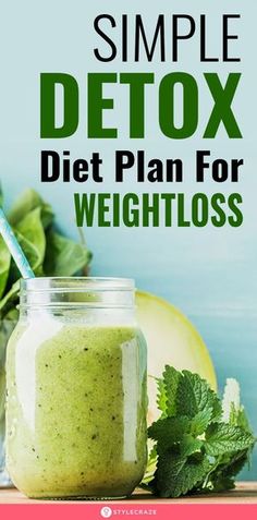 a jar filled with green smoothie next to some vegetables