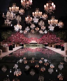 the chandelier is hanging from the ceiling and reflecting in the water at night