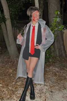 a woman dressed up as a vampire in the woods with blood all over her face