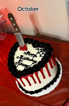 a heart shaped birthday cake with a knife stuck in the top and writing on it