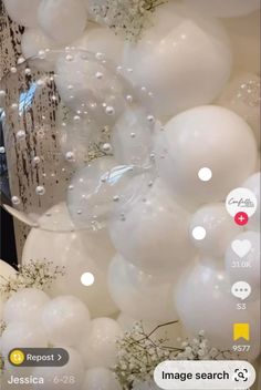 balloons are floating in the air with white flowers and greenery behind them, as well as an image search button