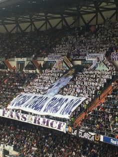 a large banner in the middle of a stadium filled with people and banners on it