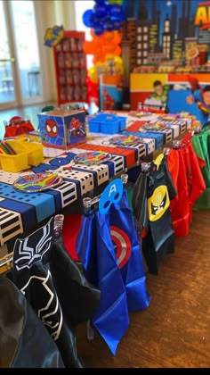 the table is set up with superhero themed bags and napkins for children's birthday party