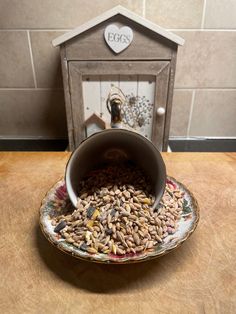 a bird feeder filled with birdseed on top of a wooden table