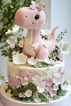 there is a cake decorated with a pink dinosaur on it