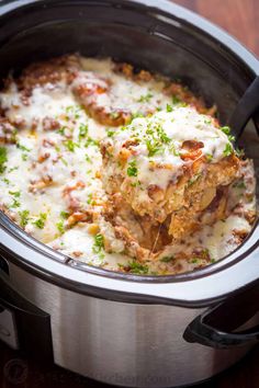 a crock pot filled with meat and cheese