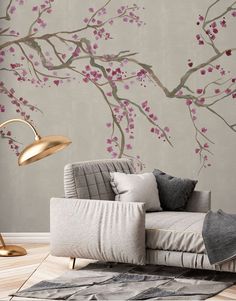 a living room with a couch, lamp and wallpaper that has pink flowers on it