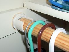 a close up of a wooden rack with rubber bands attached to it and other items in the background