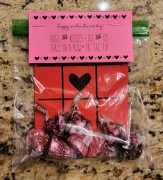 candy wrapped in cellophane on top of a counter next to a pink sign