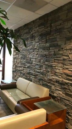 a living room filled with furniture and a stone wall