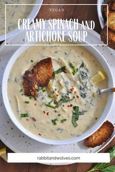 creamy spinach and artichoke soup in a white bowl with bread on the side