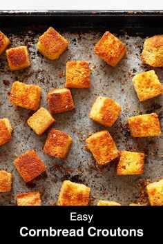 homemade cornbread croutons on a baking sheet with text overlay that reads easy cornbread croutons