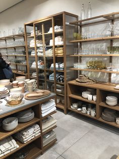 the shelves are full of dishes and glasses for sale at the store's counter