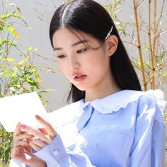 a young woman holding a piece of paper in her hands