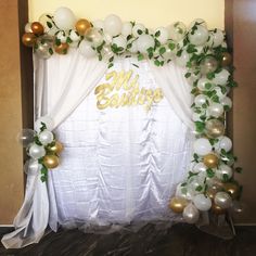 a white and gold wedding backdrop with balloons