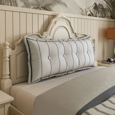 there is a bed with white sheets and pillows on the headboard in this bedroom