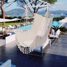 a hammock hanging from the side of a building next to a swimming pool