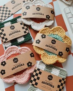 four crocheted coasters sitting on top of a table next to a keyboard