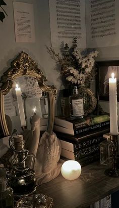 a table topped with lots of books and candles