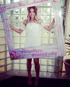 a woman holding up a photo frame with flowers on it