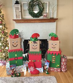 three cardboard christmas decorations sitting in front of a fireplace