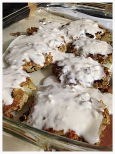 a casserole dish filled with meat and gravy covered in white sauce