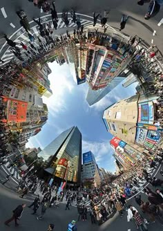 an aerial view of people standing in the middle of a busy city street, looking up into the sky