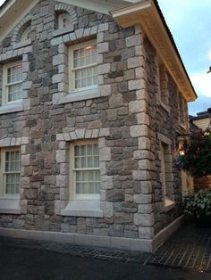 an old stone house with white windows and shutters