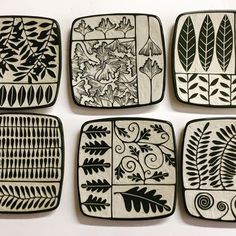 four black and white plates with designs on them