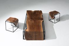 a wooden table sitting next to two stools on top of a white floor covered in wood