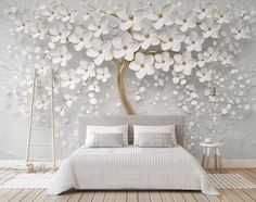 the bedroom is decorated with white flowers on the wall, and there are two tables in front of the bed