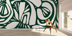 a chair sitting in front of a green and white wall with an abstract design on it