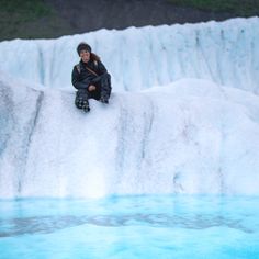 a person sitting on the edge of a frozen waterfall