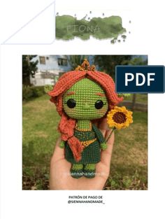 an image of a green doll with red hair holding a flower in it's hand