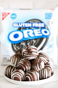 chocolate covered oreo cookies on a white plate next to a bag of oreos