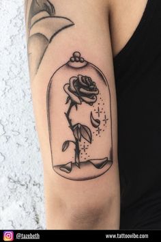 a woman's arm with a rose in a glass jar tattoo on it,