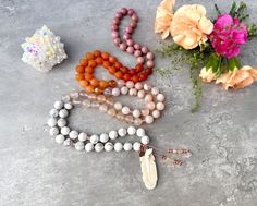 "Mala Necklace with Sakura Cherry Blossom Agate, Orange Aventurine, Rhodonite and Howlite Mala Beads, Yoga Spiritual Meditation Necklace 108 Prayer Beads Boho Gift for Her This is an original design by Vibe Jewelry. Discover serenity with our Mindful Vibe Jewelry collection of Mala Necklaces. This Meditation Accessory is more than just that - it's a wearable journey, a Beaded Story of conscious living and self-discovery. Embrace Fashion with Intent as you wear this mala, a reminder of your inner peace journey.  ♥ All Malas are saged to cleanse the energy before they are shipped to their new home ♥ * G E M S T O N E * P R O P E R T I E S * ♥ ORANGE AVENTURINE is considered a stone of good luck, fortune, and a manifestor of exciting new possibilities. It has been called the \"Whisper Stone\" Spiritual Beaded Necklaces For Meditation With Faceted Beads, Spiritual Faceted Agate Beads, Spiritual White Agate Beaded Necklaces, Spiritual Oval Beads Crystal Necklaces For Healing, Spiritual Oval Beads Crystal Necklace For Healing, Spiritual Healing Crystal Necklaces With Oval Beads, Yoga Spiritual, Orange Aventurine, Cherry Blossom Agate