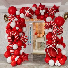 a red and white balloon arch with christmas decorations