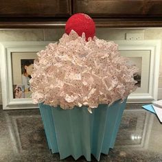 a cupcake made out of tissue paper sitting on top of a counter