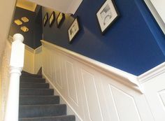 the stairs are painted blue and white with pictures on the wall