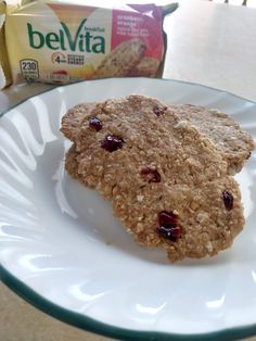 two oatmeal cookies on a plate next to a carton of milk