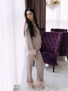 Indulge in luxury with our stunning cappuccino bride pajama set. This elegant loungewear features beautiful feather trim on the sleeves and pant legs, offering a touch of sophistication to your nightly routine. Perfect for lounging at home or as a chic gift for someone special, this set is made from high-quality, soft fabric that ensures both comfort and style. Why You'll Love It: - Stylish Design: The feather trim adds a unique and glamorous touch to your loungewear. - Comfortable Fit: Designed Elegant Beige Sleepwear For Wedding Night, Elegant Long Loungewear Sets, Elegant Loungewear Sets, Elegant Lounging Sets With Long Pants, Feathered Pajamas, Satin Pajamas With Feathers, Feather Trim Pajamas, Black Feather Pajamas, Sleeper Feather Pajamas